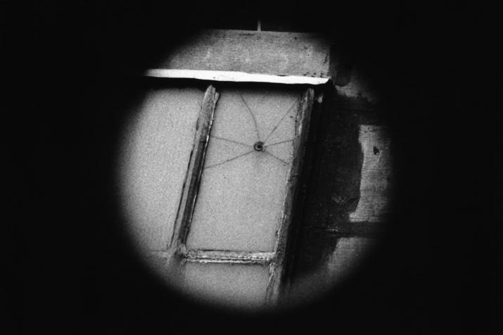 black background with a black and white circle in the center that displays a cracked window.