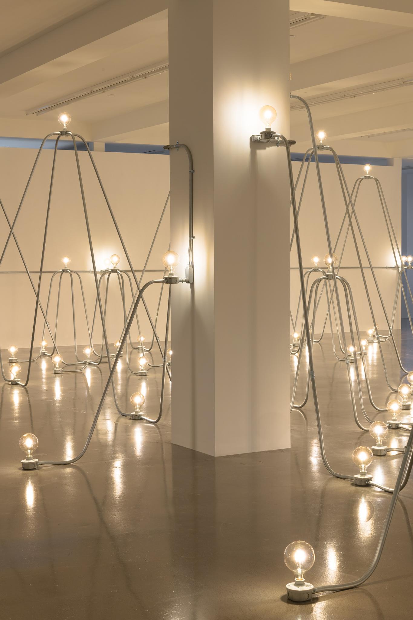 Nancy Holt's sculpture Electrical System, made of metal conduit and lightbulbs, in an exhibition