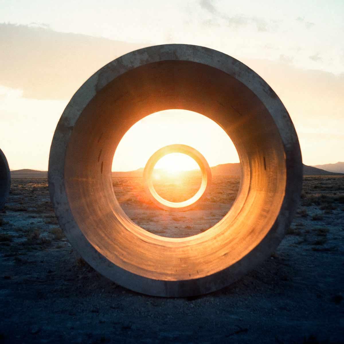 A close up of a golden sunrise through Holt's Sun Tunnels.