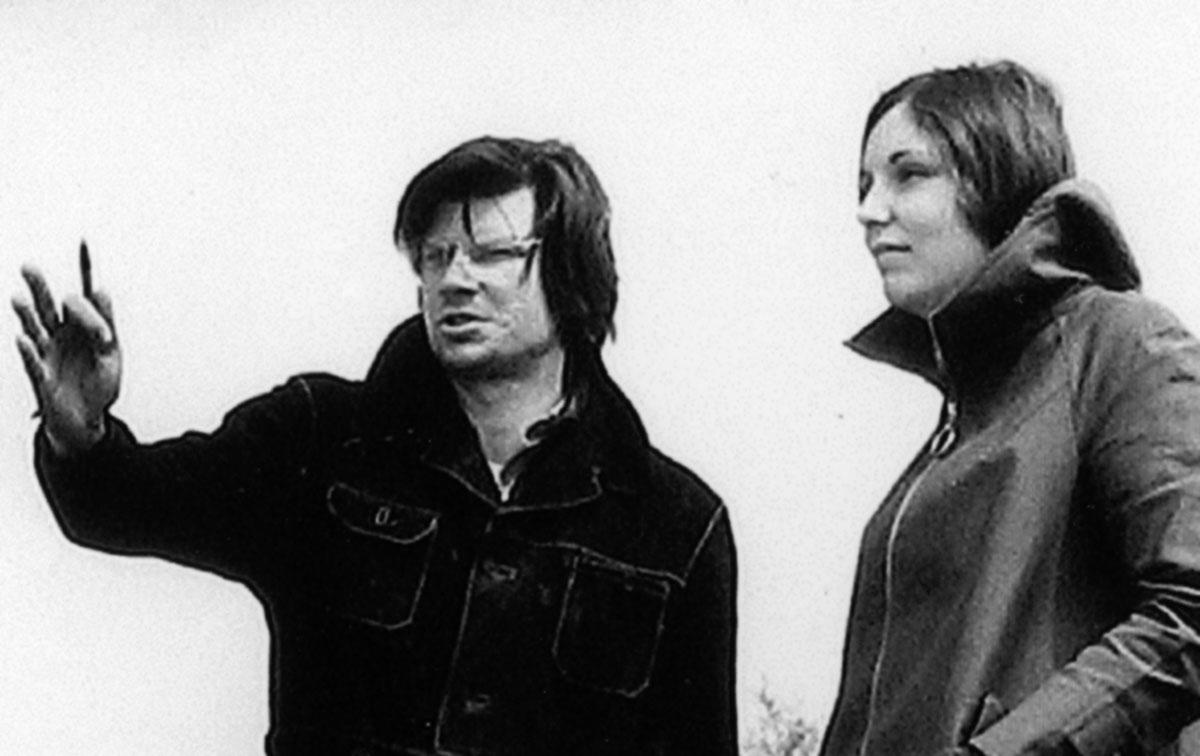 black and white image of man on left with his hand outstretched gesturing and a woman on the right looking toward the direction he is pointing
