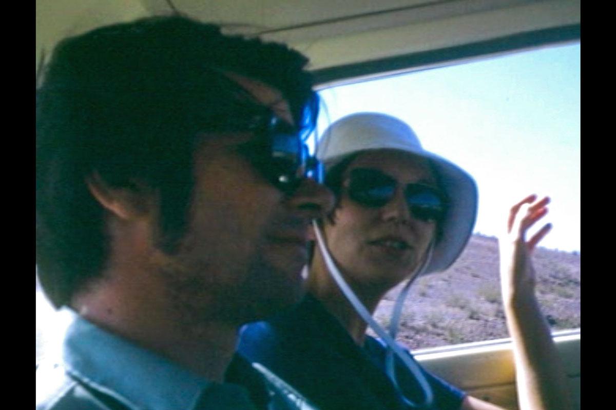 a young man and woman sitting side by side in the backseat of a car
