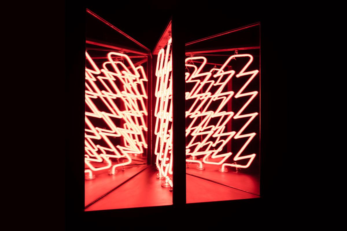 neon lights in a zig zag pattern in a three panel glass box