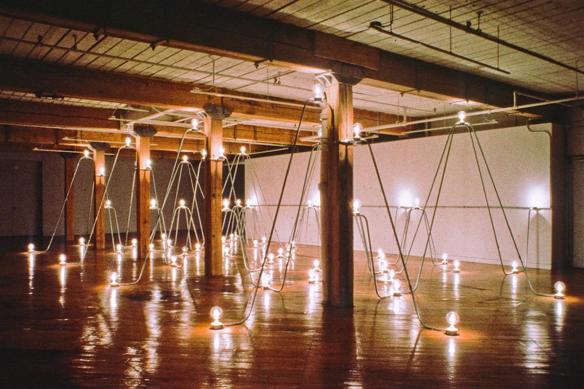 room filled with arches of conduit and lightbulbs