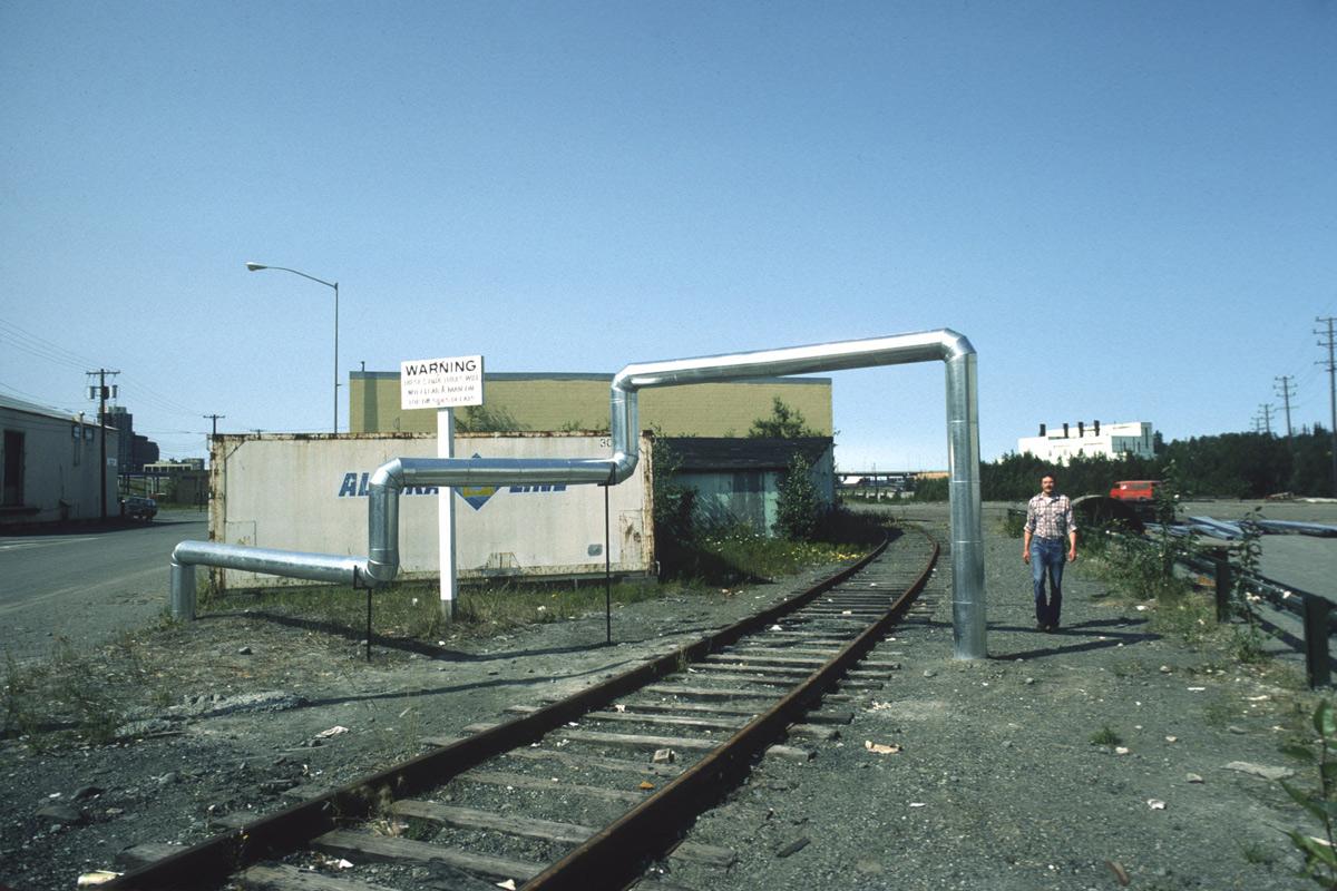 steel duct zig zags through the air over a railroad