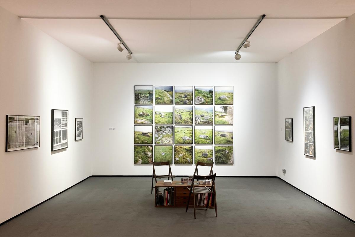 a gallery booth with photographs on white walls 