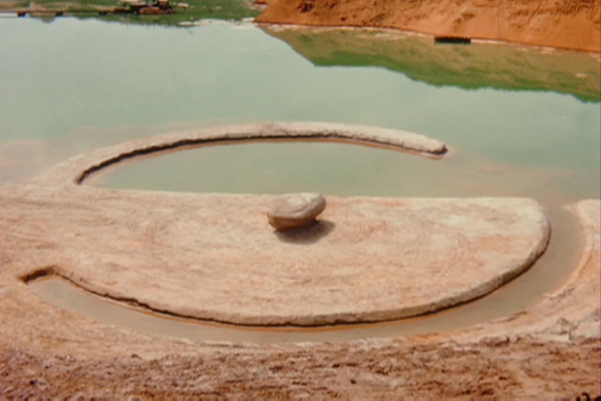 a circular jetty and canal with a large boulder in the center