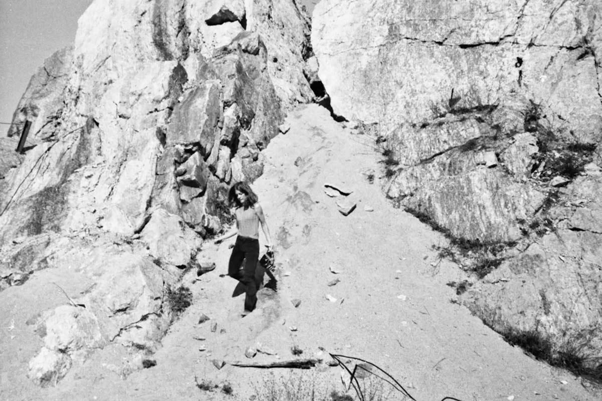 a woman walking down a sandy hill