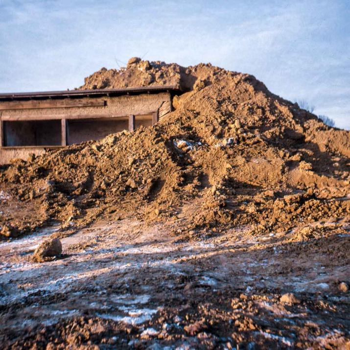 A 1970 work by Robert Smithson. Smithson piled earth atop an old woodshed on the campus of Kent State University until the center beam cracked.