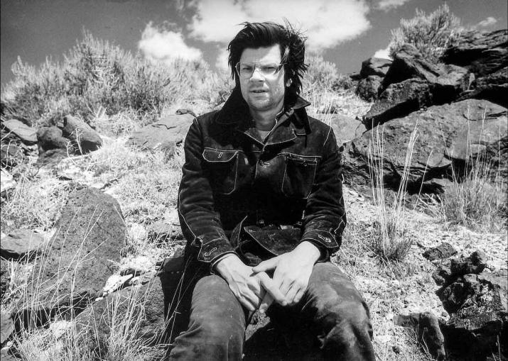 A balck and white photo of Robert Smithson at the site of the Spiral jetty in 1970.