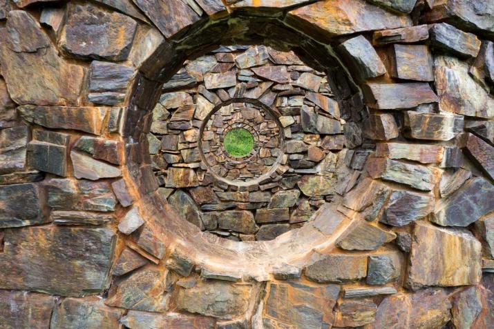Stone walls receding in space with concentric circular holes in the center 