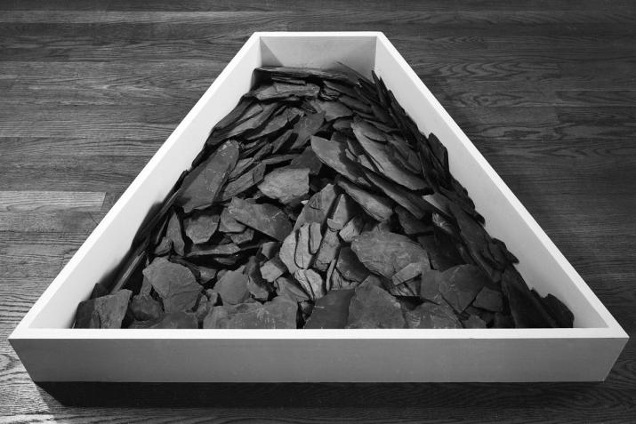 a polygonal bin full of dark slate, placed on a wood floor