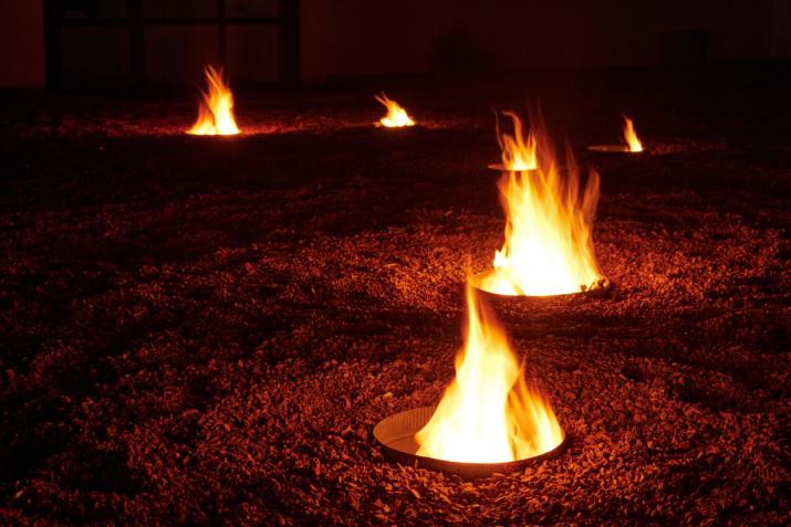 circular fire pits burning at night