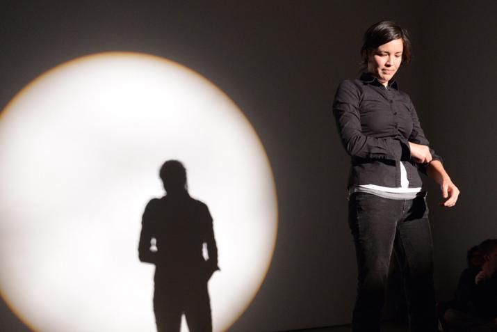 Maria Hupfield standing in a circular spotlight