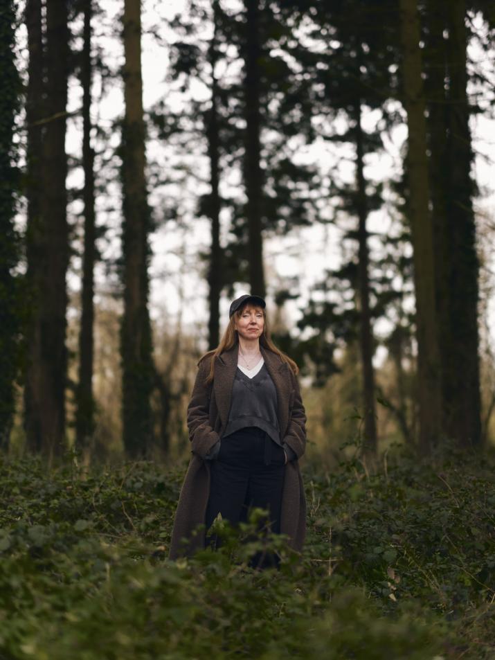 the artist Susan Philipsz standing in a wooded landscape
