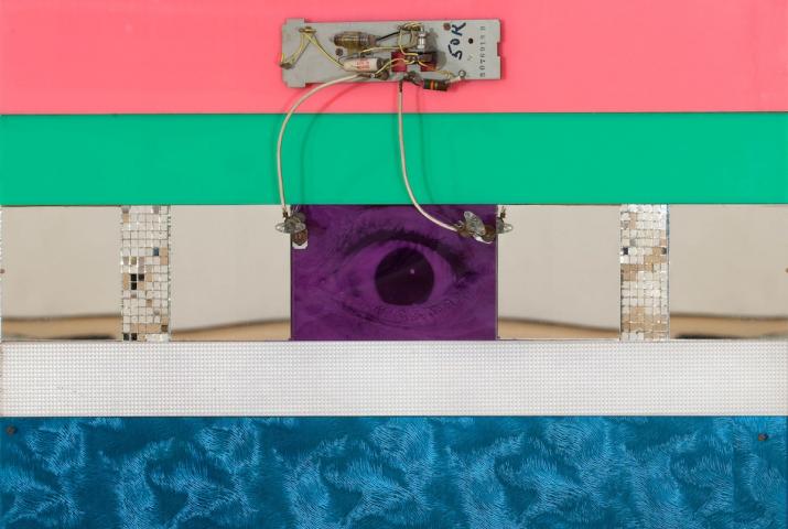 a wall based sculpture with an eye at the center