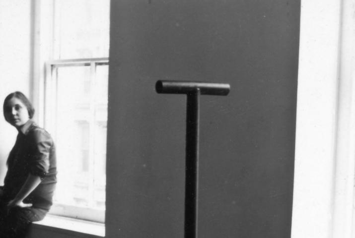 Nancy Holt looking at a Locator sculpture while sitting in a widow