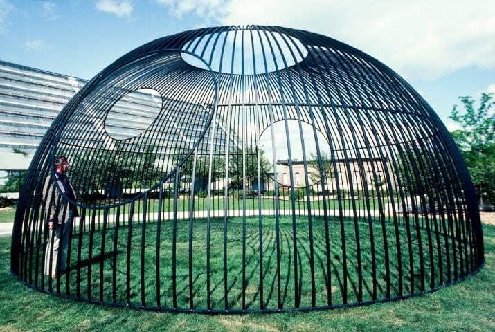 an outdoor sculpture made of steel bars in a hemisphere