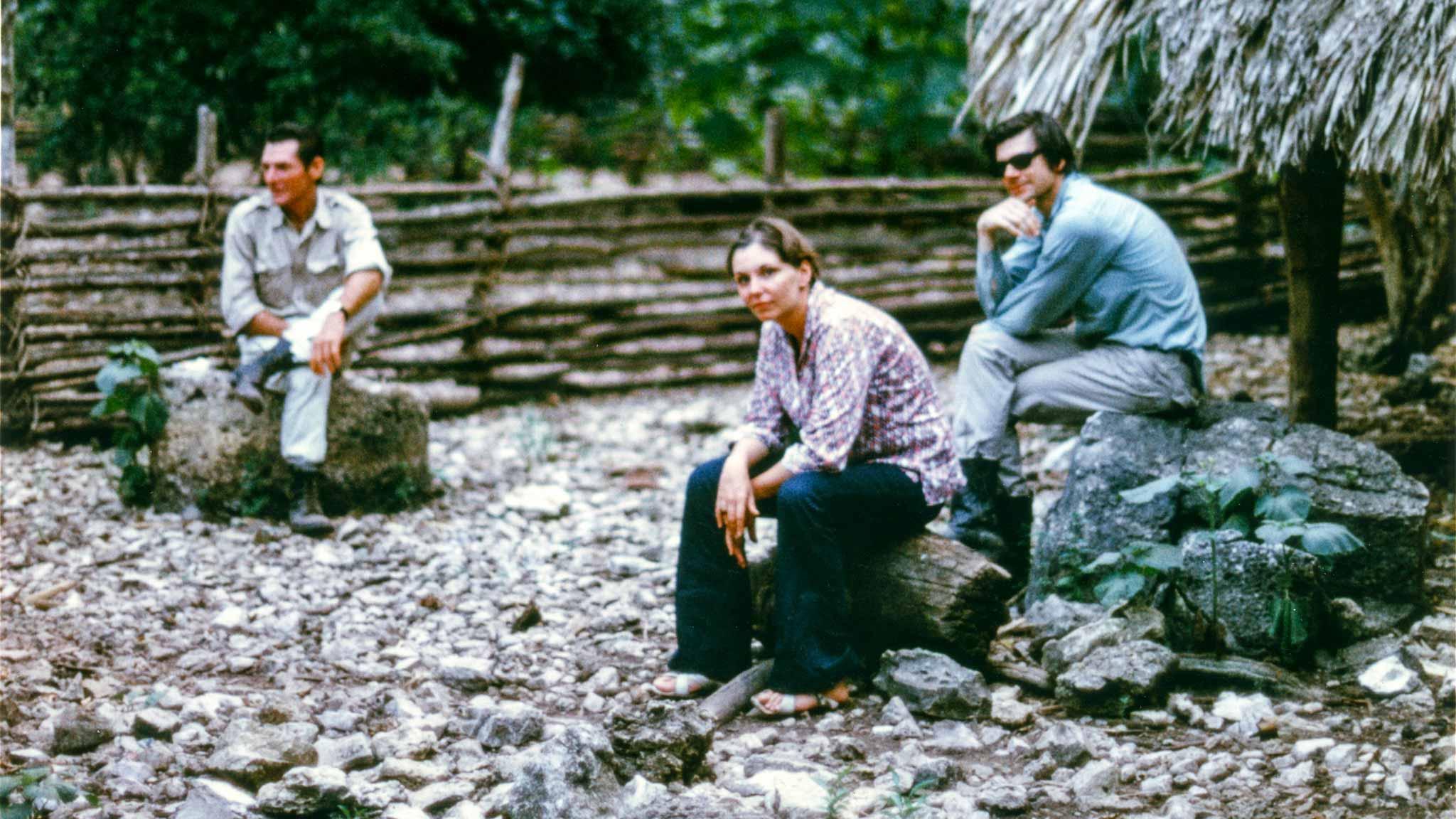 Three figures sitting on rocks in the yucatan