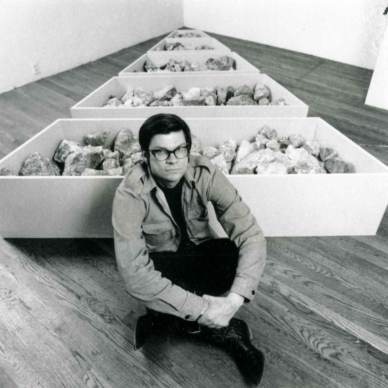 Robert Smithson, in a gallery environment, next to his work, Franklin Nonsite