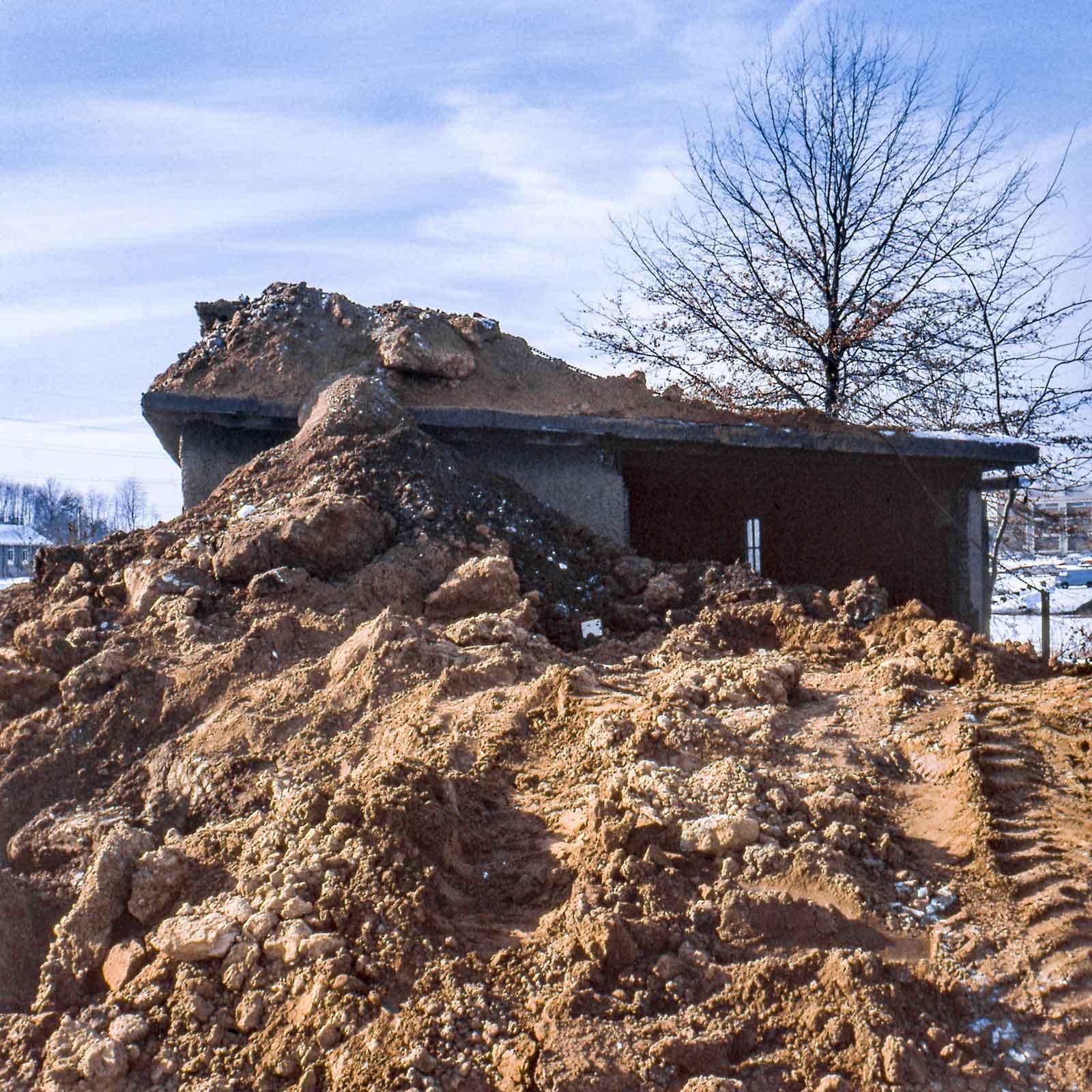 A 1970 work by Robert Smithson. Smithson piled earth atop an old woodshed on the campus of Kent State University until the center beam cracked.
