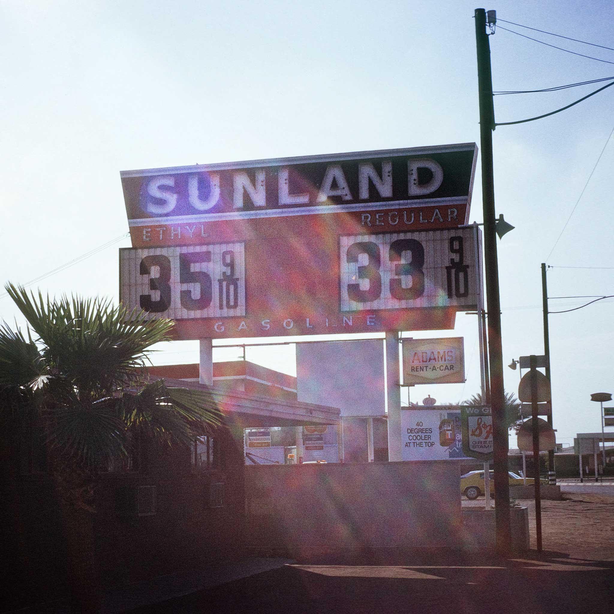 A gas station sign with gas prices and the word "Sunland"