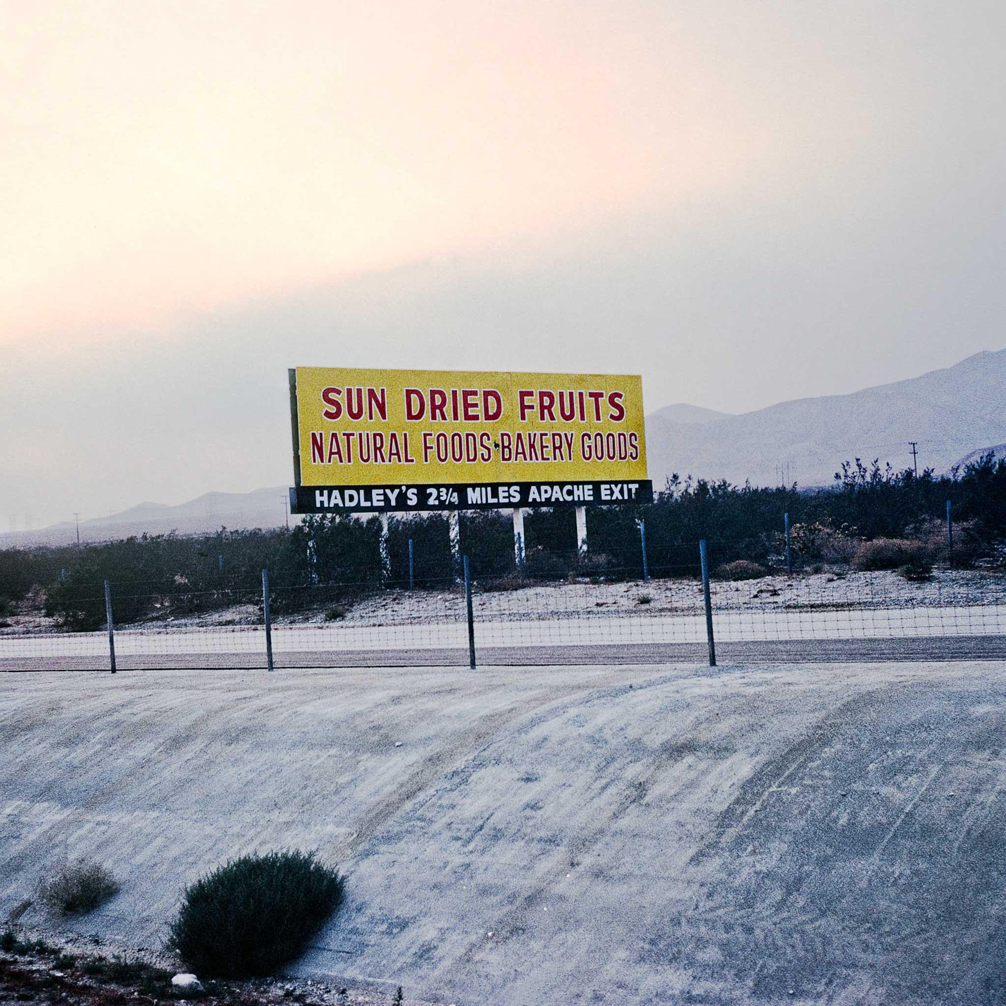 A sign that says "Sun Dried Fruits" above a concrete culvert