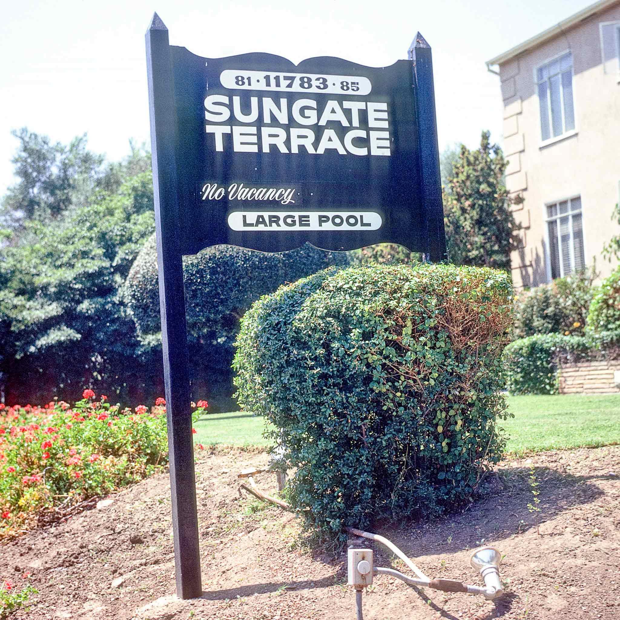 A wood sign that says "Sungate Terrace"