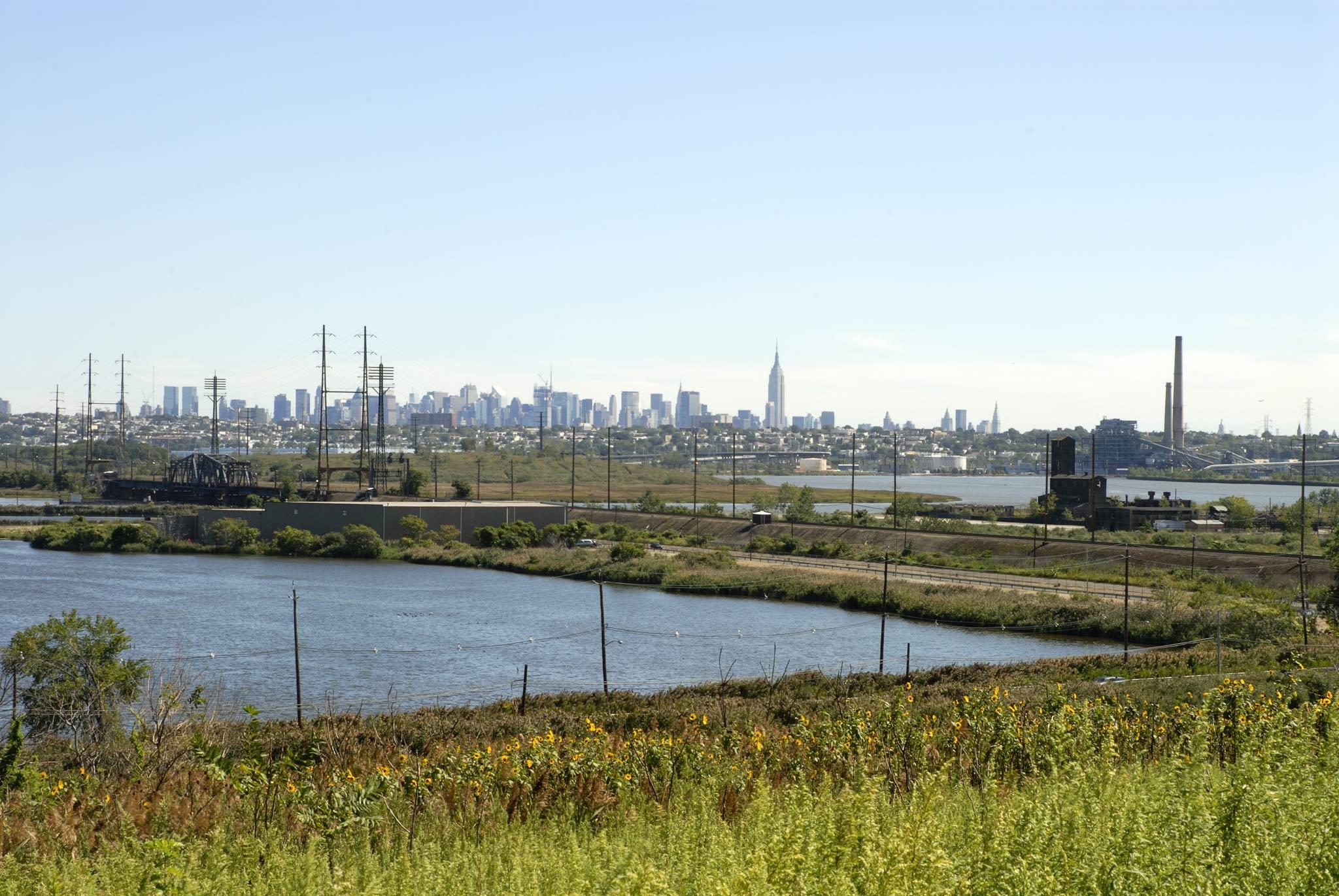 View of the Manhattan skyline in the distance with roads and electricity infrastructure visible in the foreground