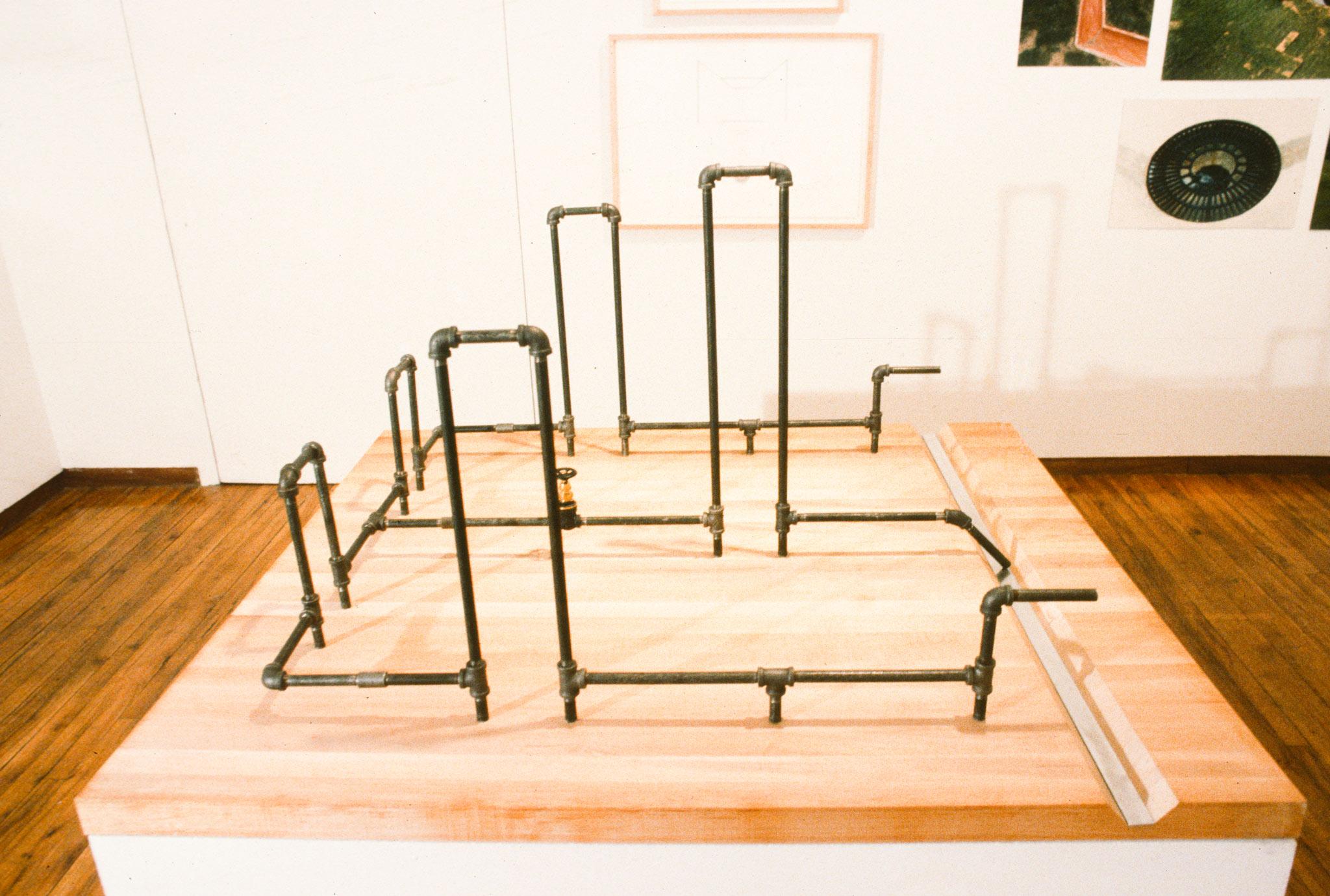 a small model of made of metal pipes to depict a square strucuture