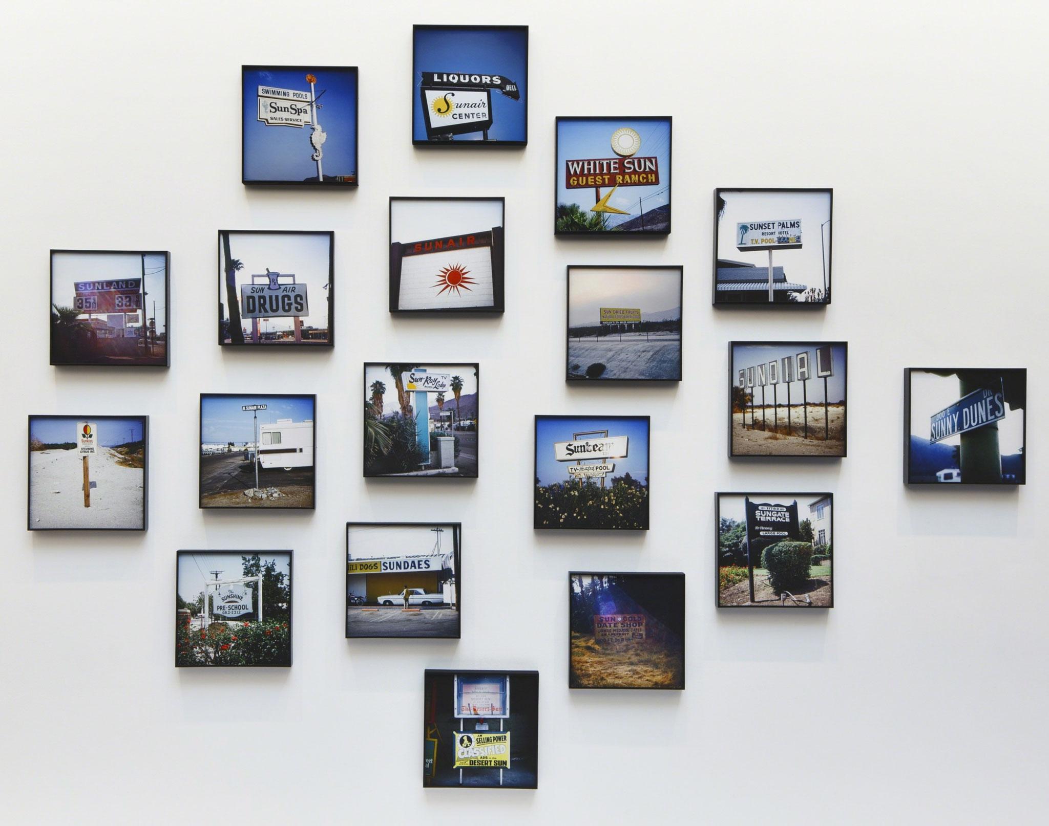 an arrangement of framed photographs displayed on a a white wall