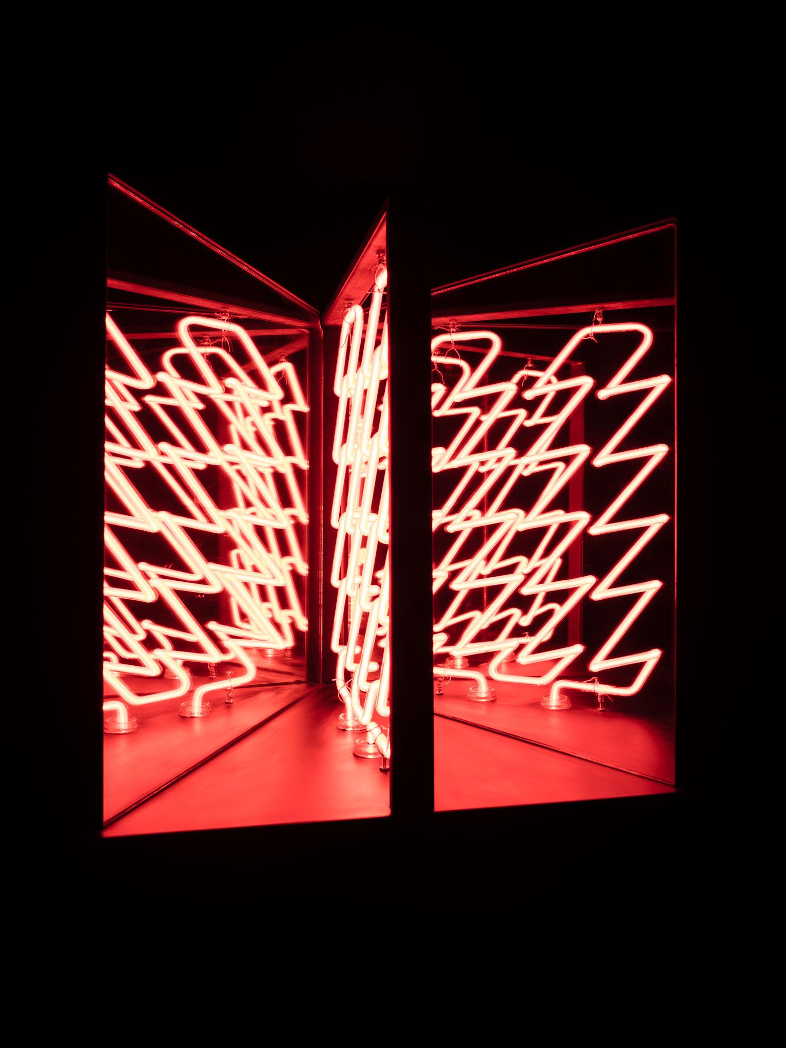 neon lights in a zig zag pattern in a three panel glass box