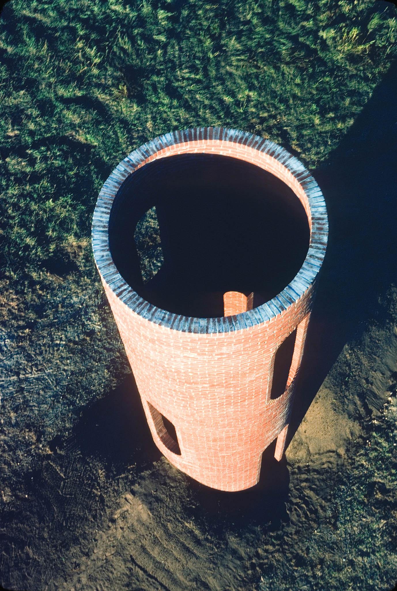aerial image looking down on a tall circular brick structure with an open top