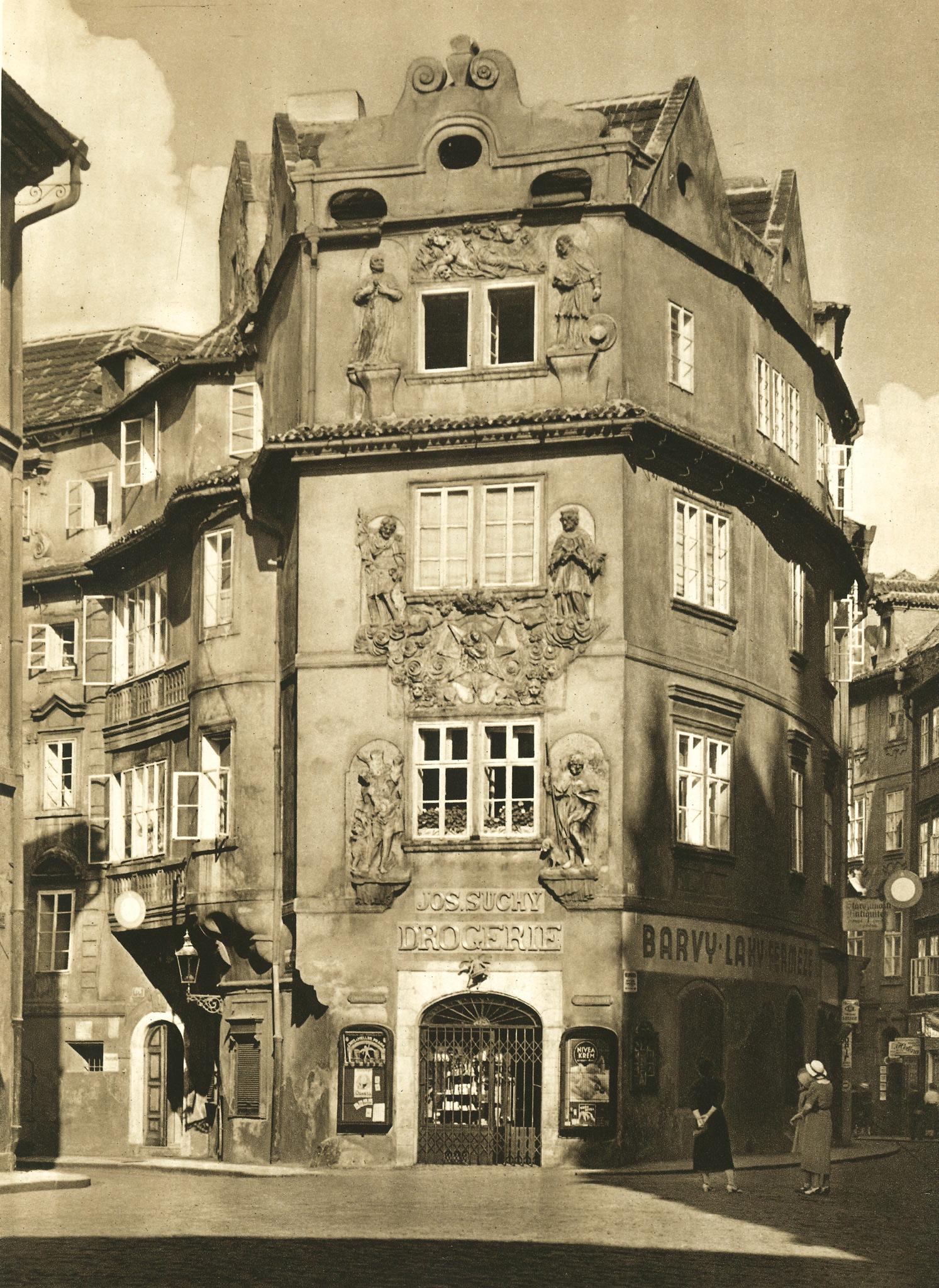 black and white image of a four story building with a 'drogerie' on the ground floor