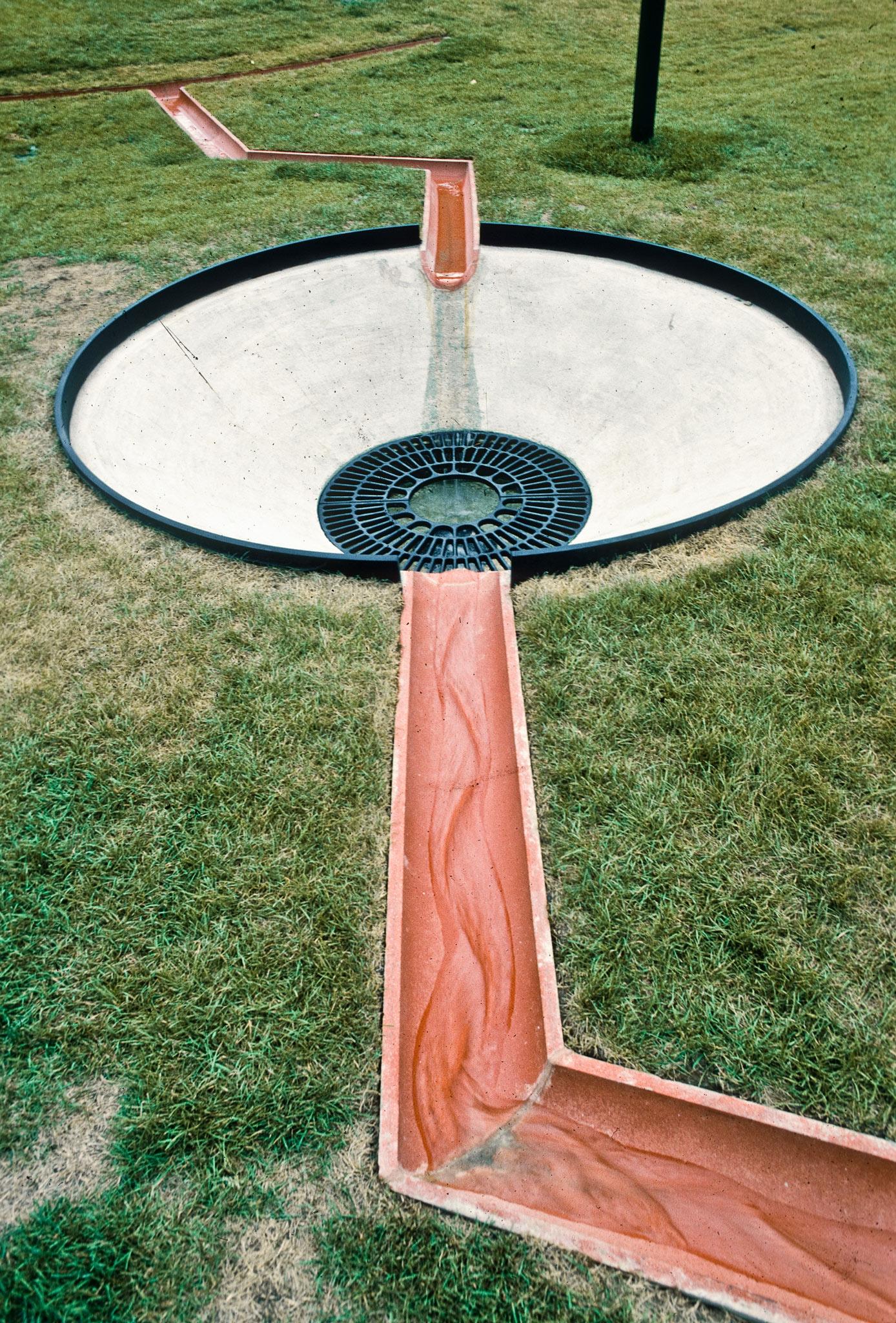 a land drainage sculpture made of terra cotta pipes and a concrete drain in Toronto