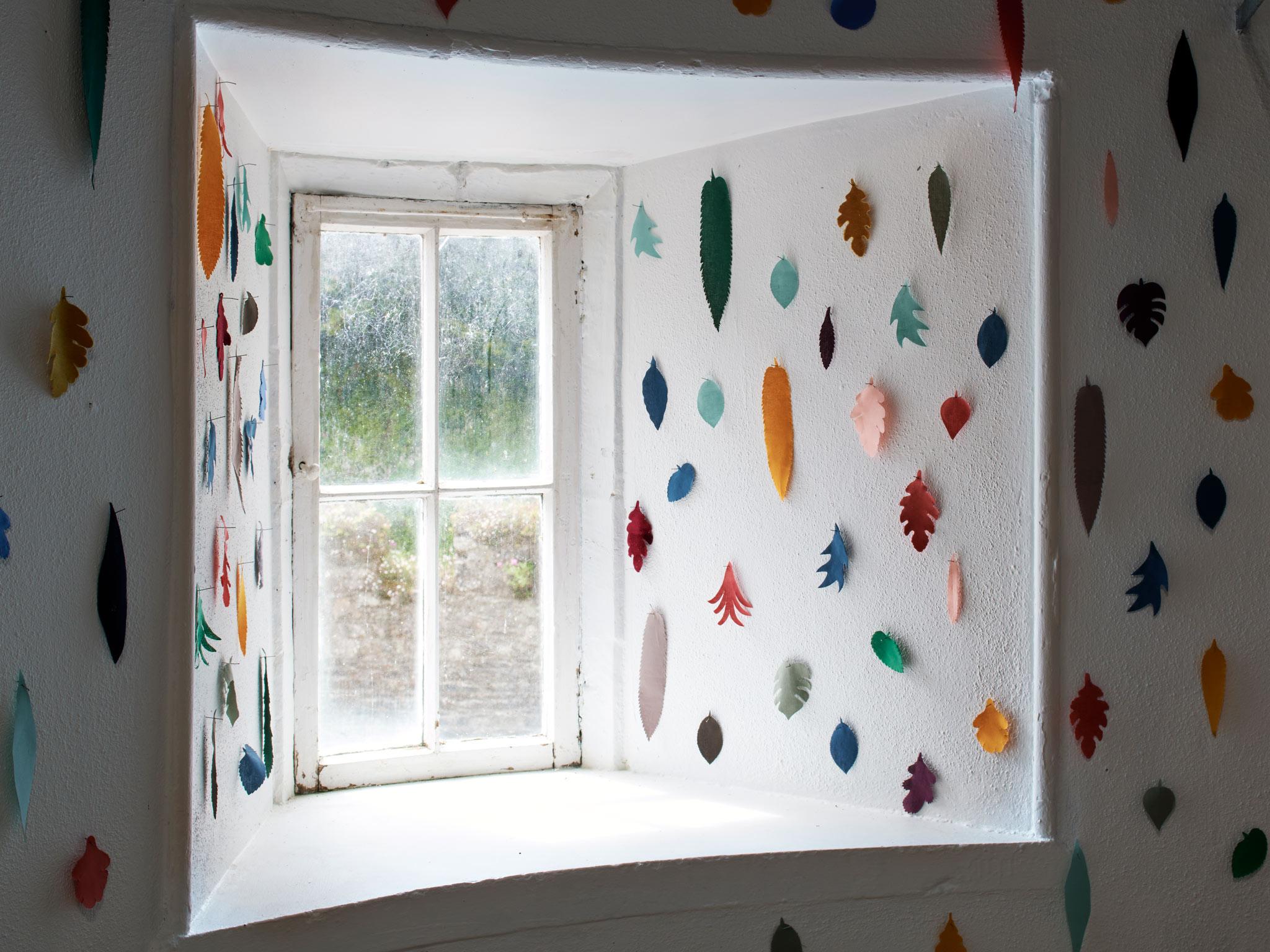 an installation of fabric leaves around a white window sill