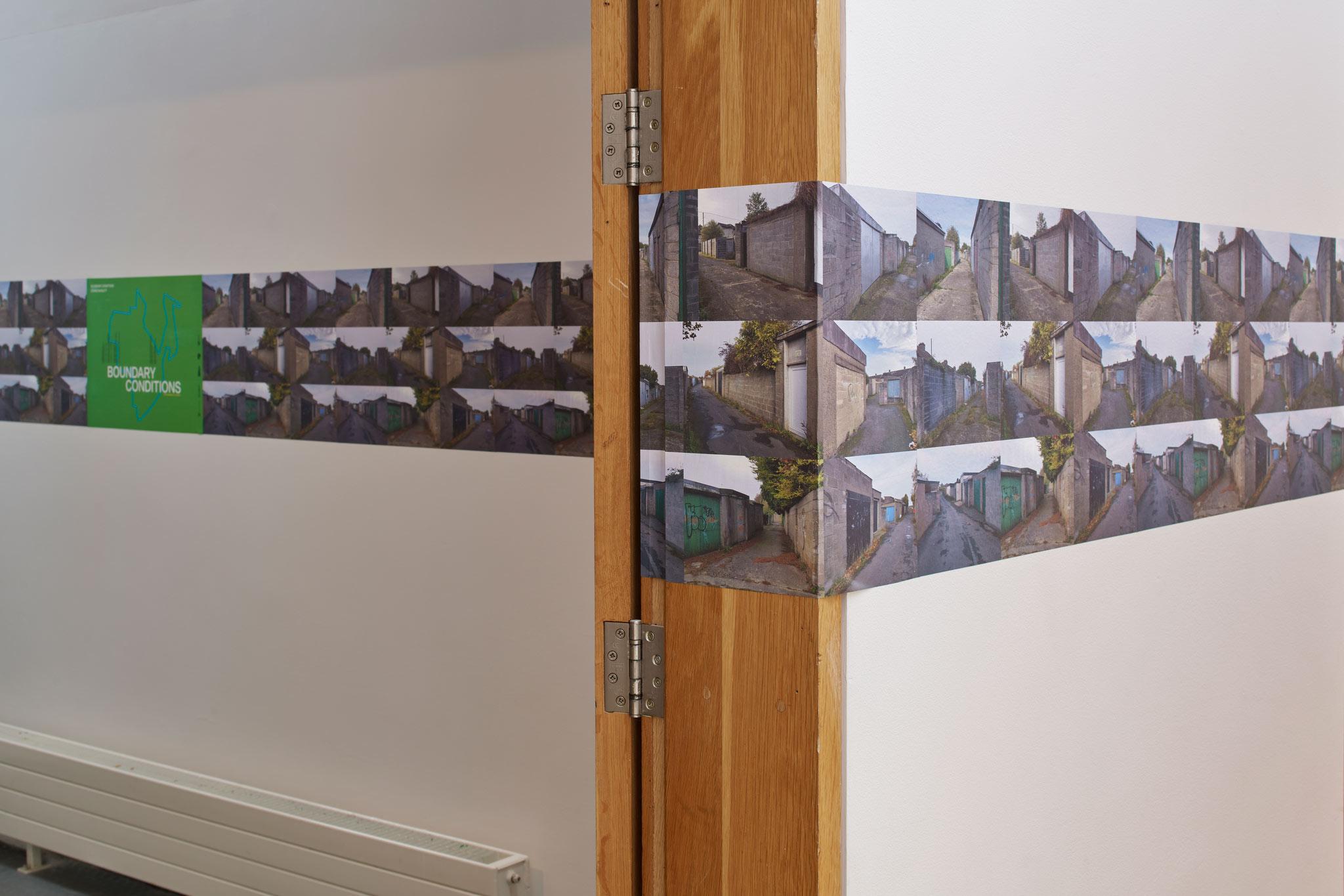 images wrapping around the walls and door frame of a gallery space
