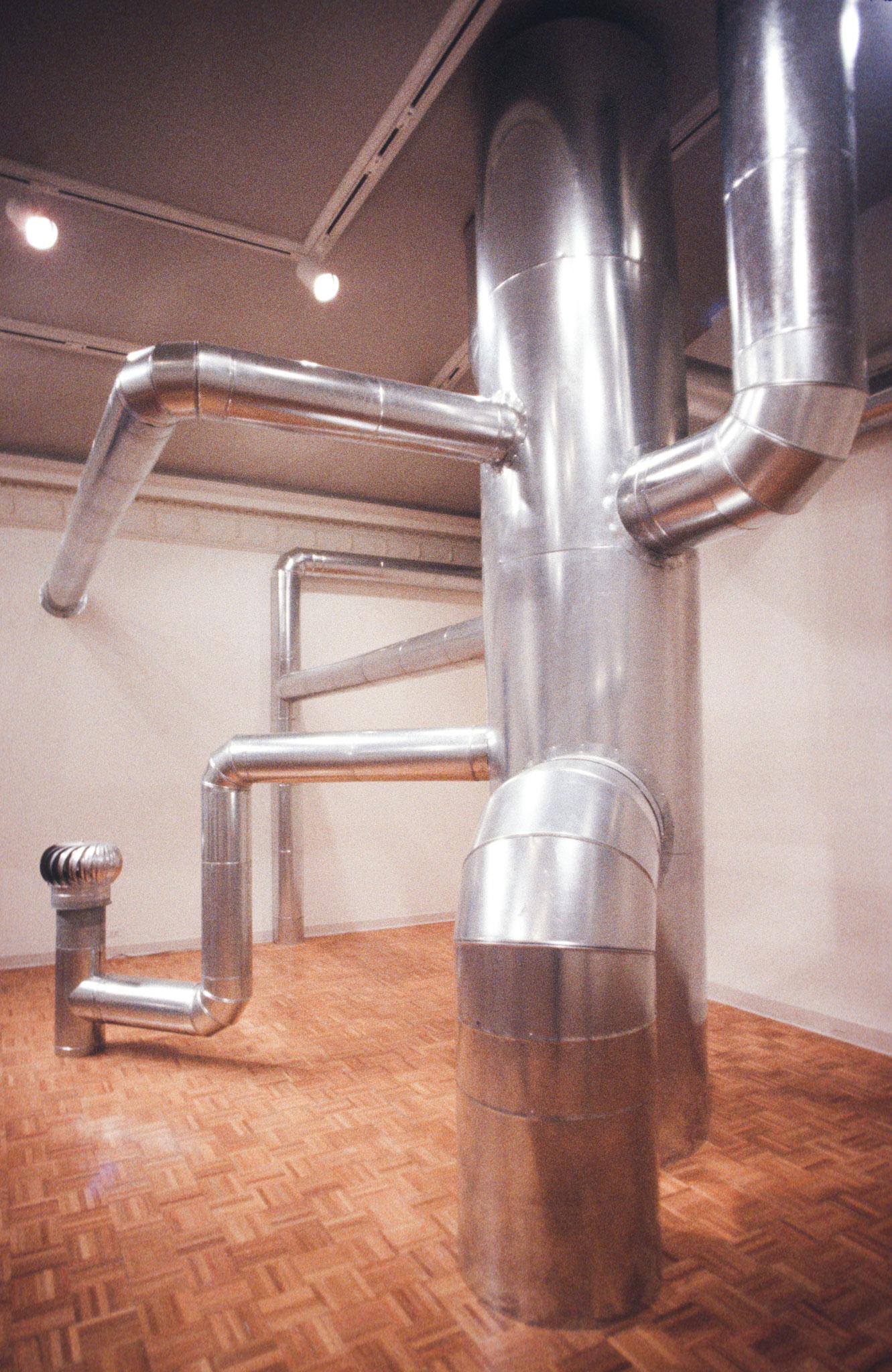 a gallery space filled with steel duct that attaches to the floor, walls, and ceiling
