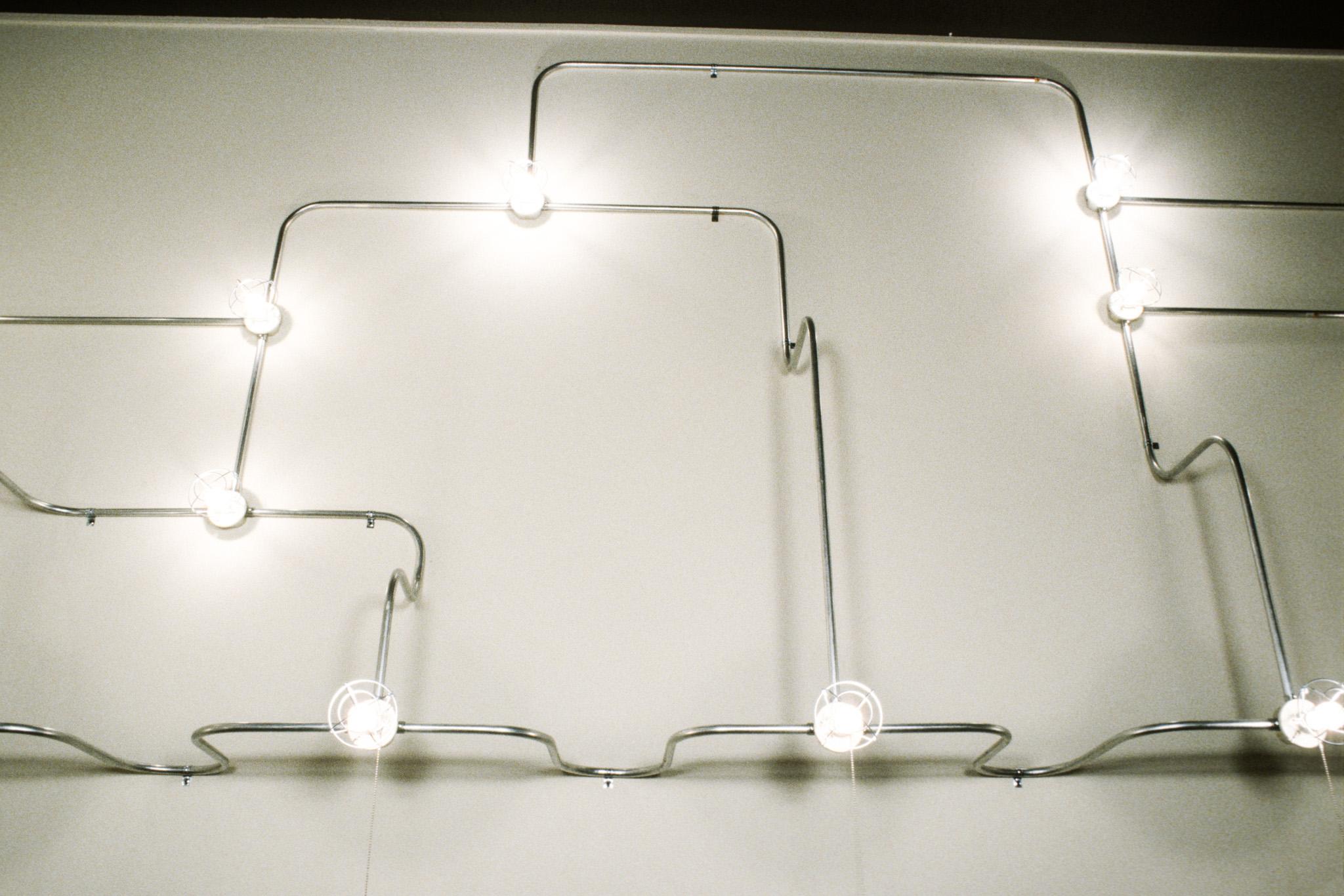 Nancy Holt's sculpture Electrical Lighting for Reading Room made of lightbulbs and conduit along three walls