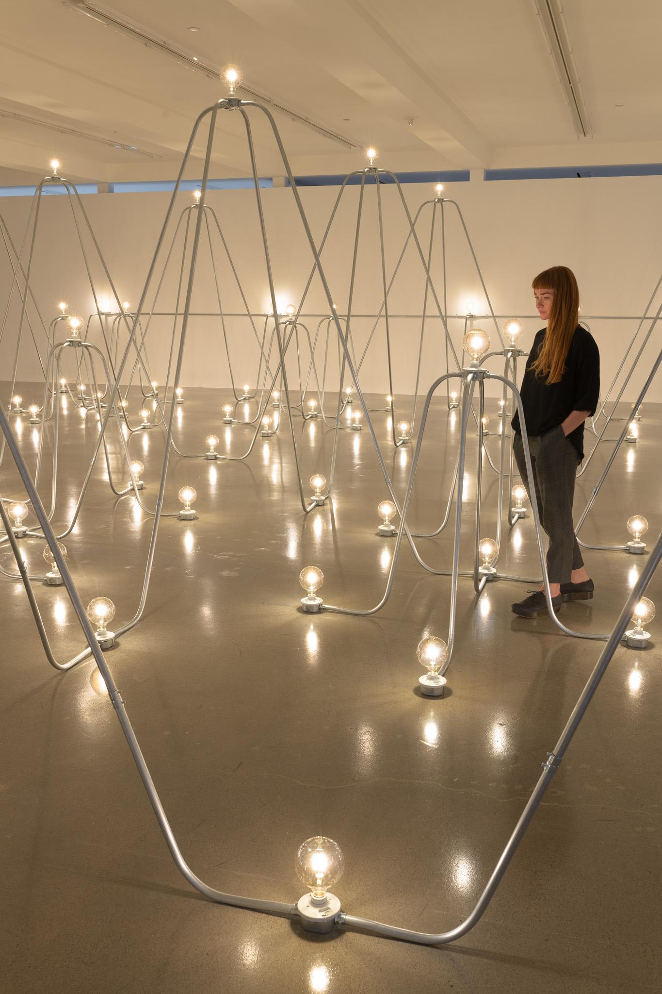 Nancy Holt's sculpture Electrical System, made of metal conduit and lightbulbs, in an exhibition