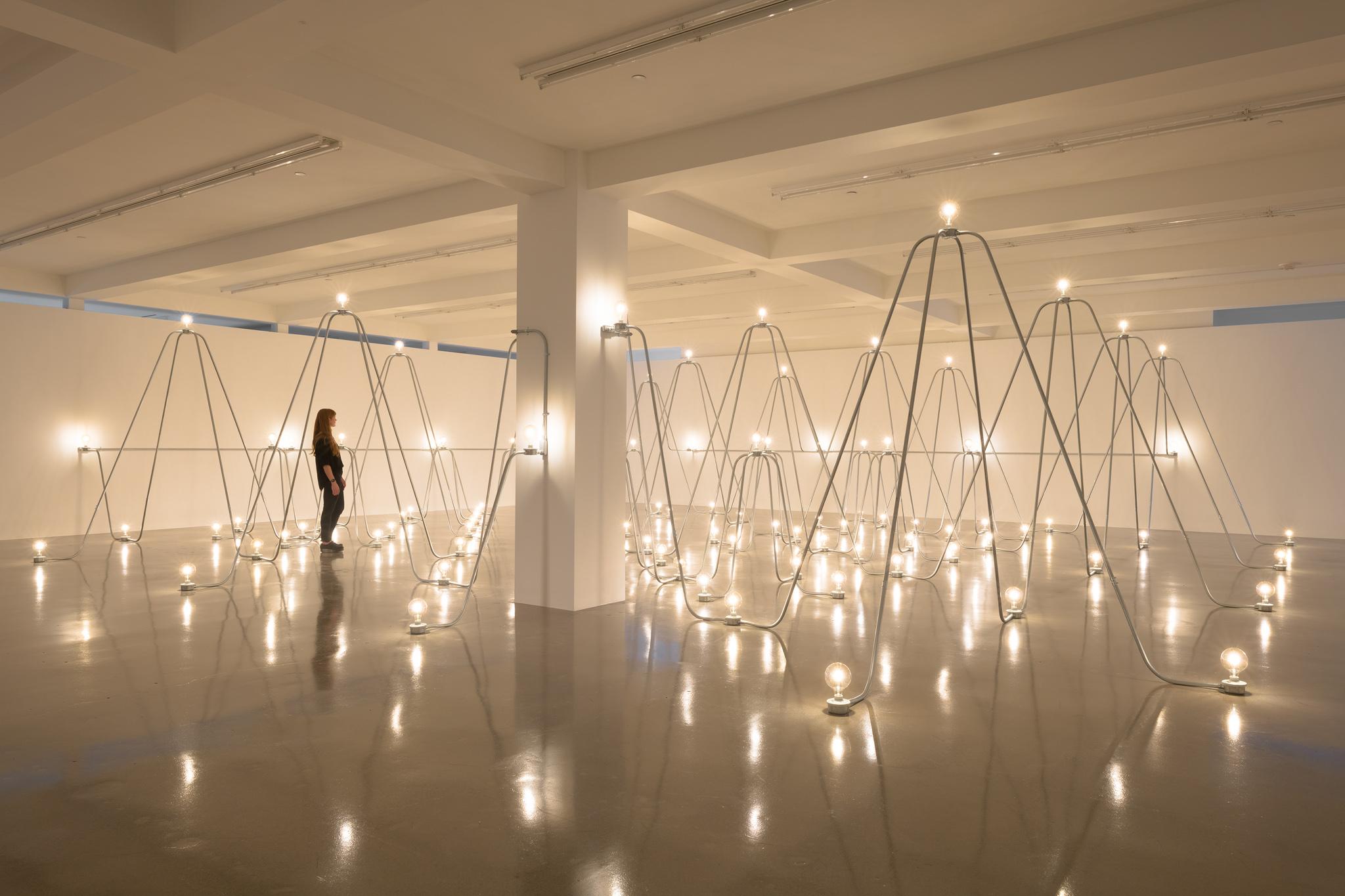 A person standing inside Nancy Holt's Electrical System at Sprueth Magers LA