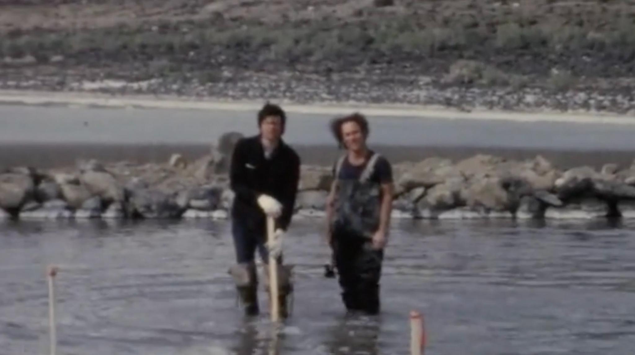 two people standing in knee-deep water with a 