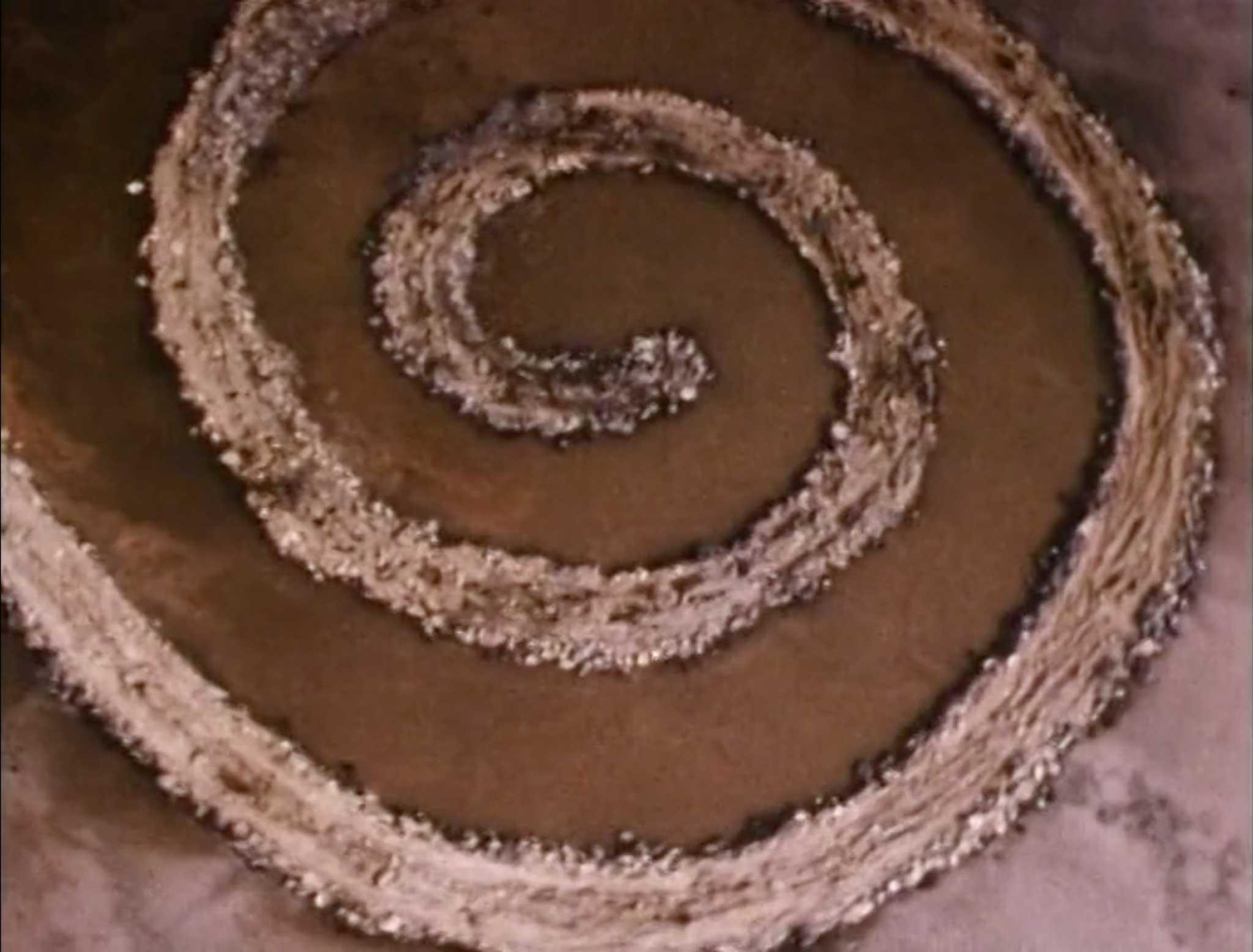 a still from the film Spiral Jetty showing an aerial view of the Jetty