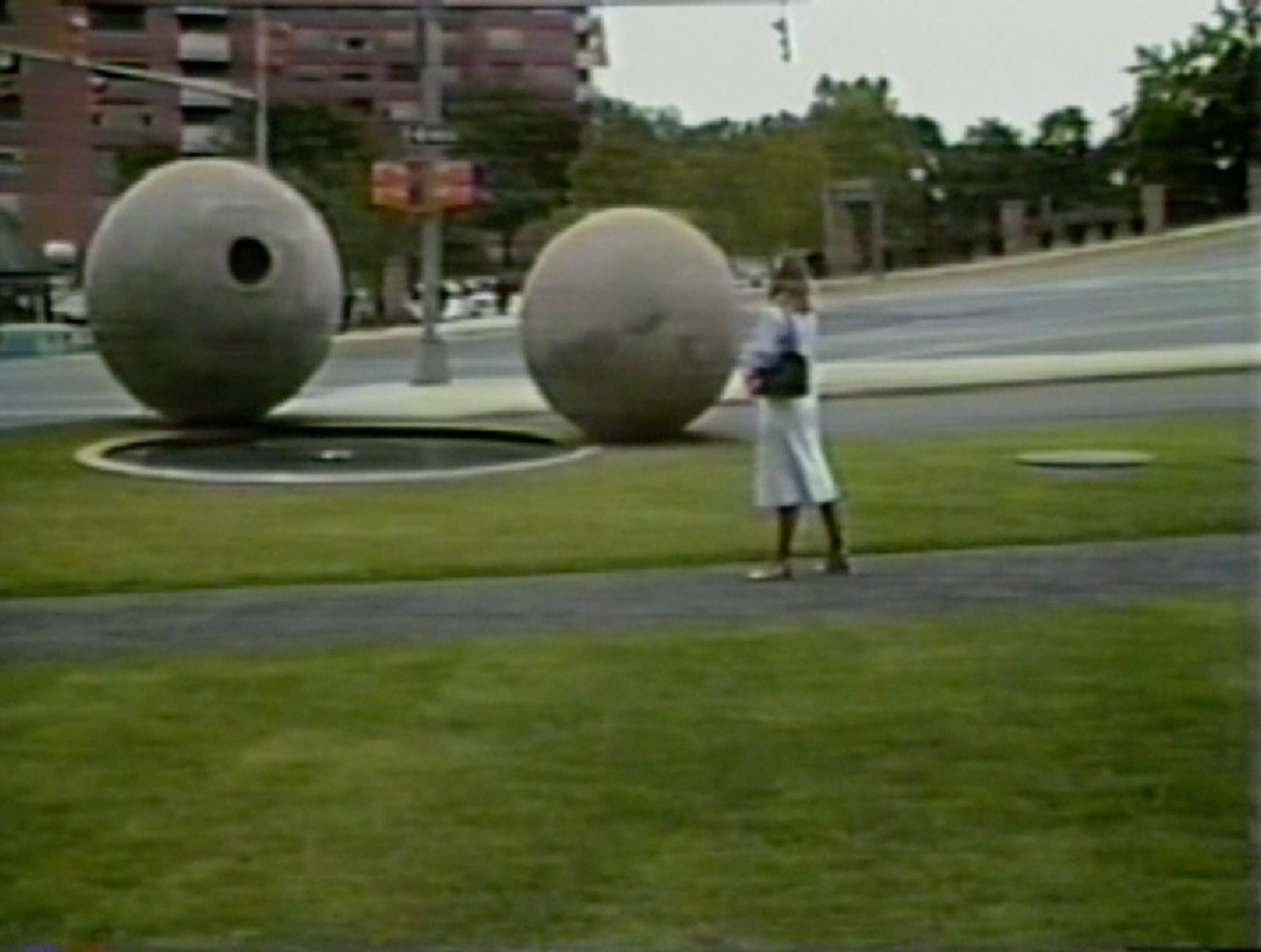 a person standing and looking at the large spheres in Dark Star Park