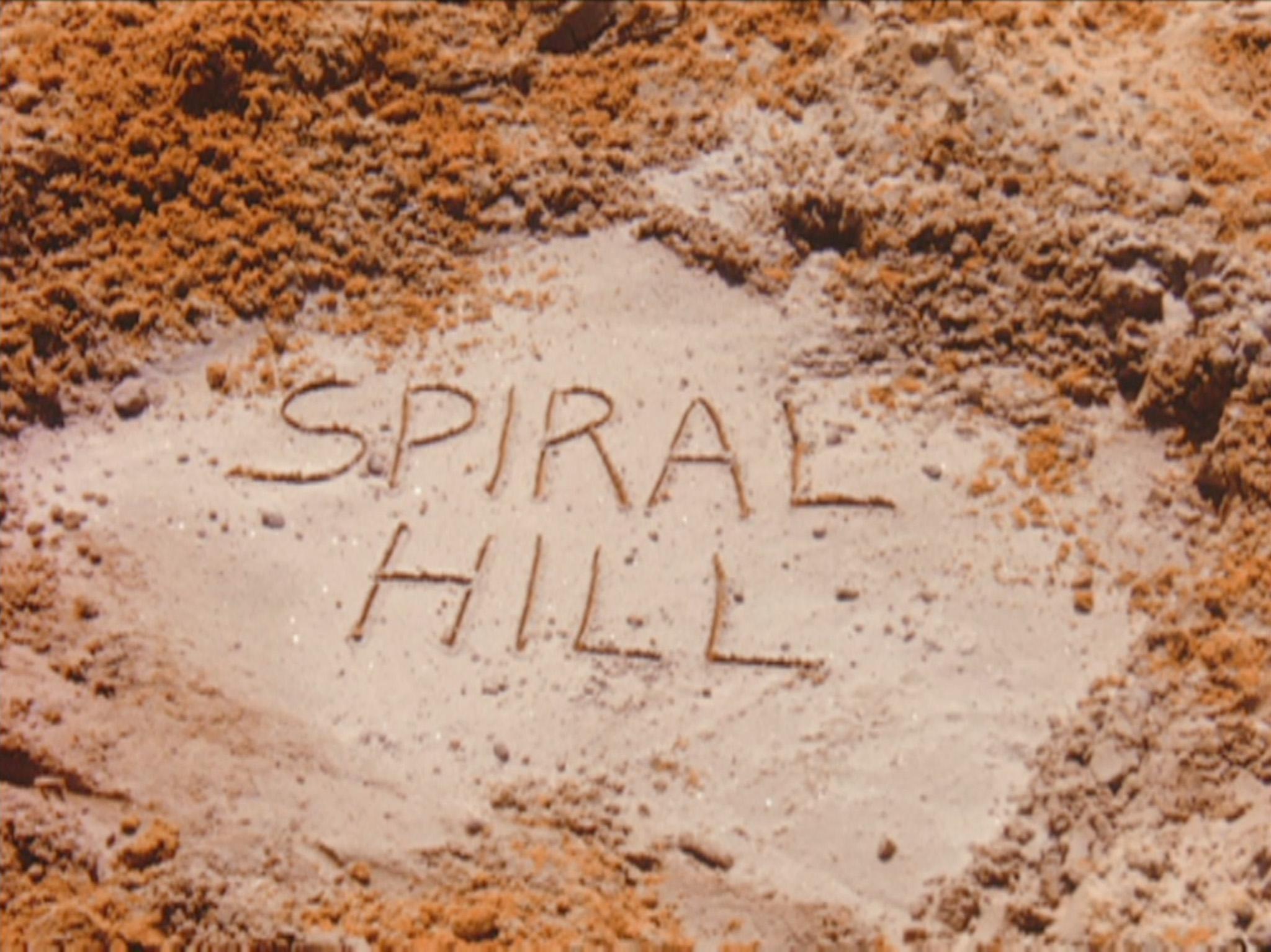 a still from Breaking Ground that shows Spiral Hill written in the sand