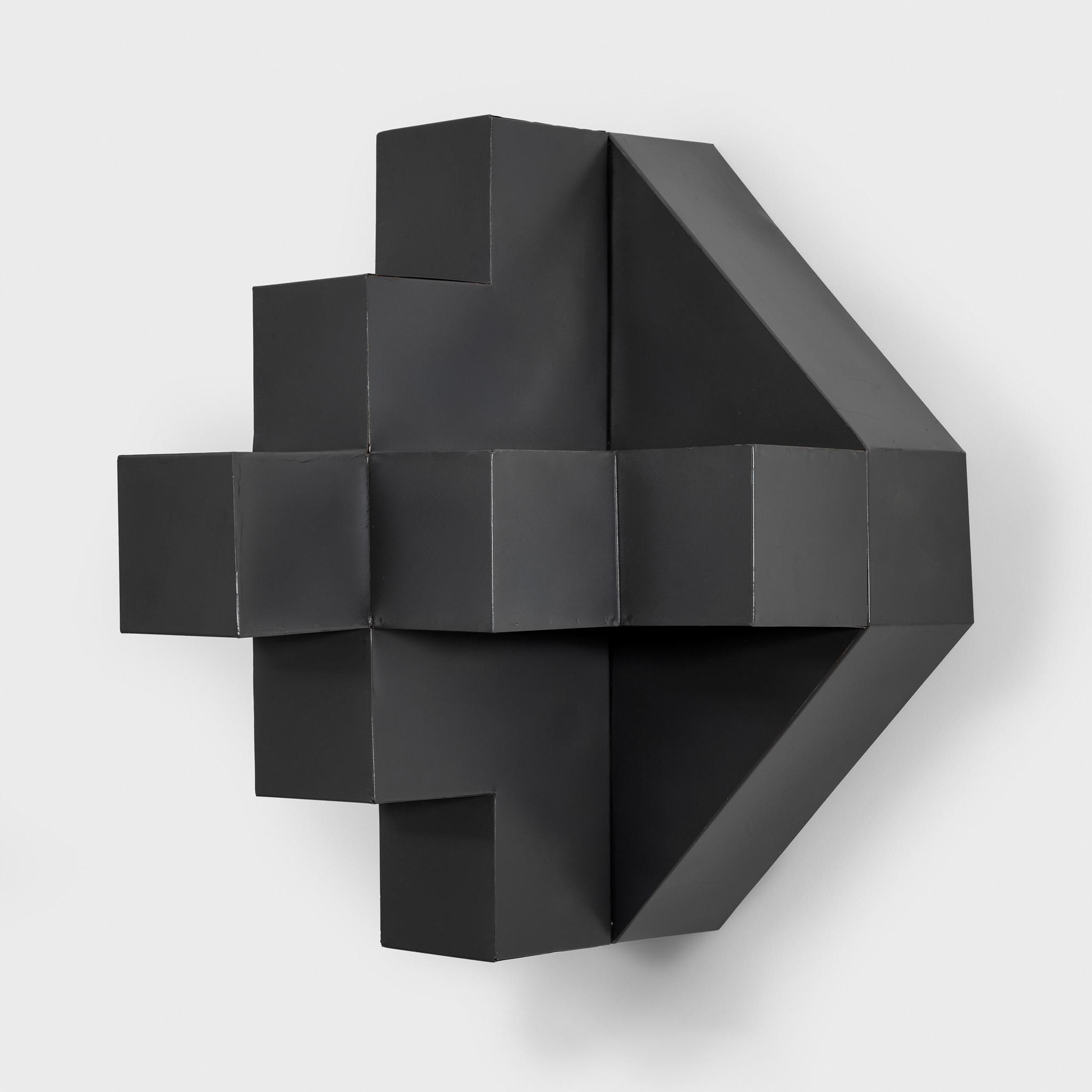 Black painted metal sculpture in a geometric form hanging on the wall 
