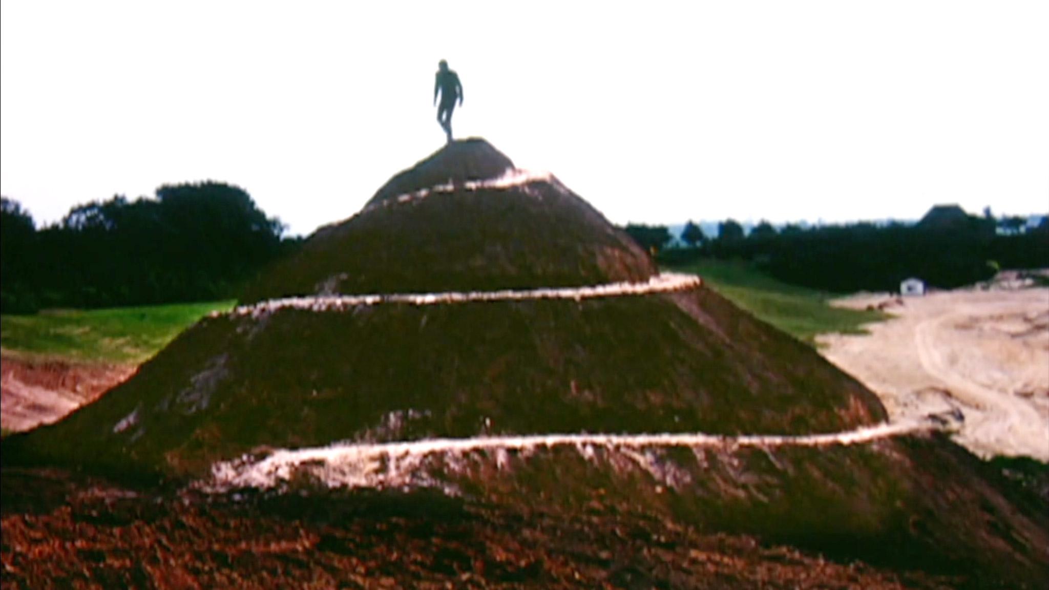 a man running down a white spiral path on a small hill