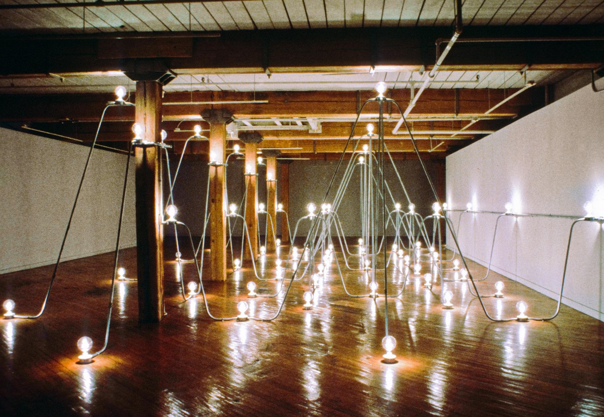 Nancy Holt's Electrical System made of conduit and lightbulbs installed in an exhibition space