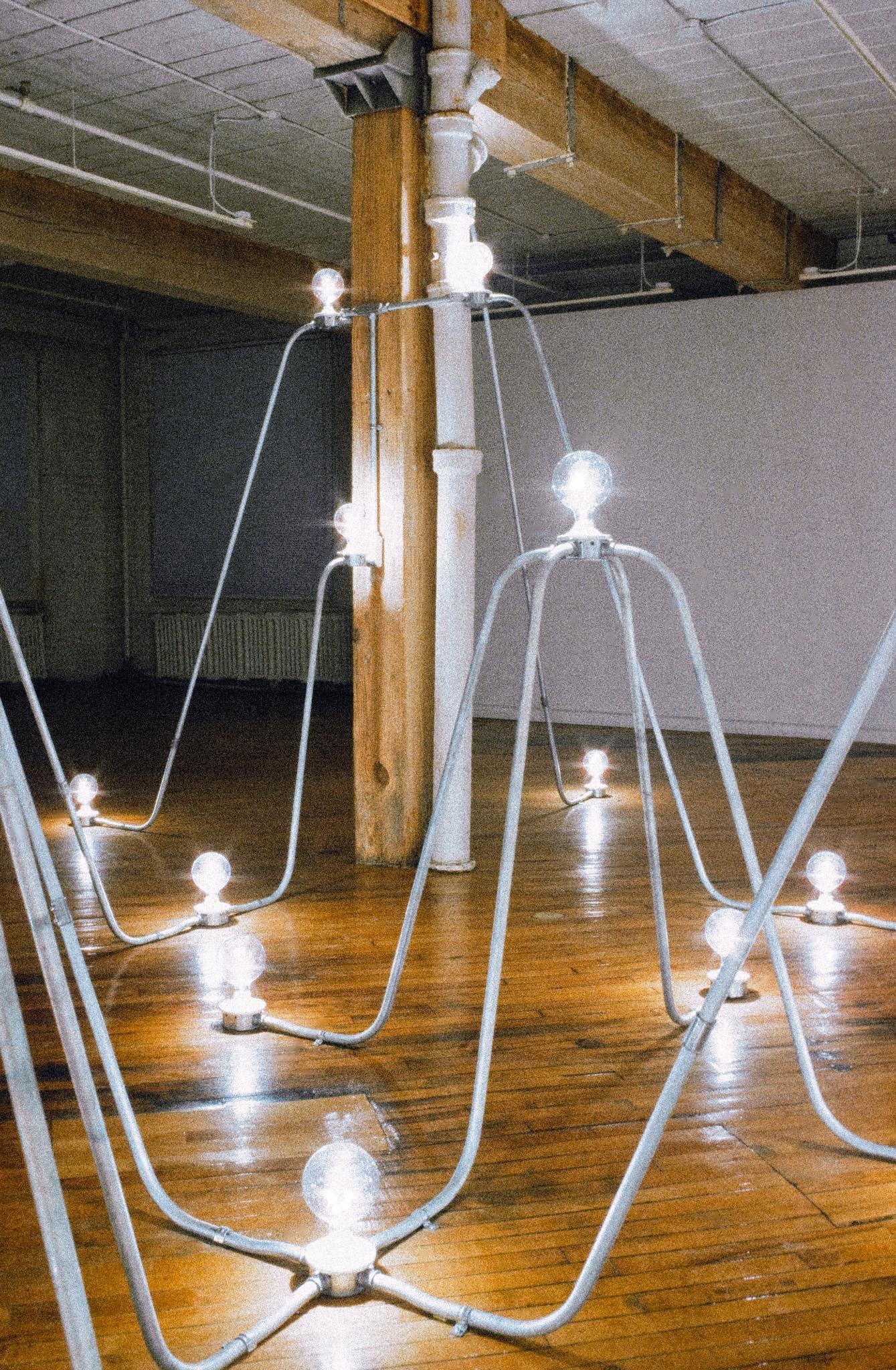 Nancy Holt's Electrical System made of conduit and lightbulbs installed in an exhibition space