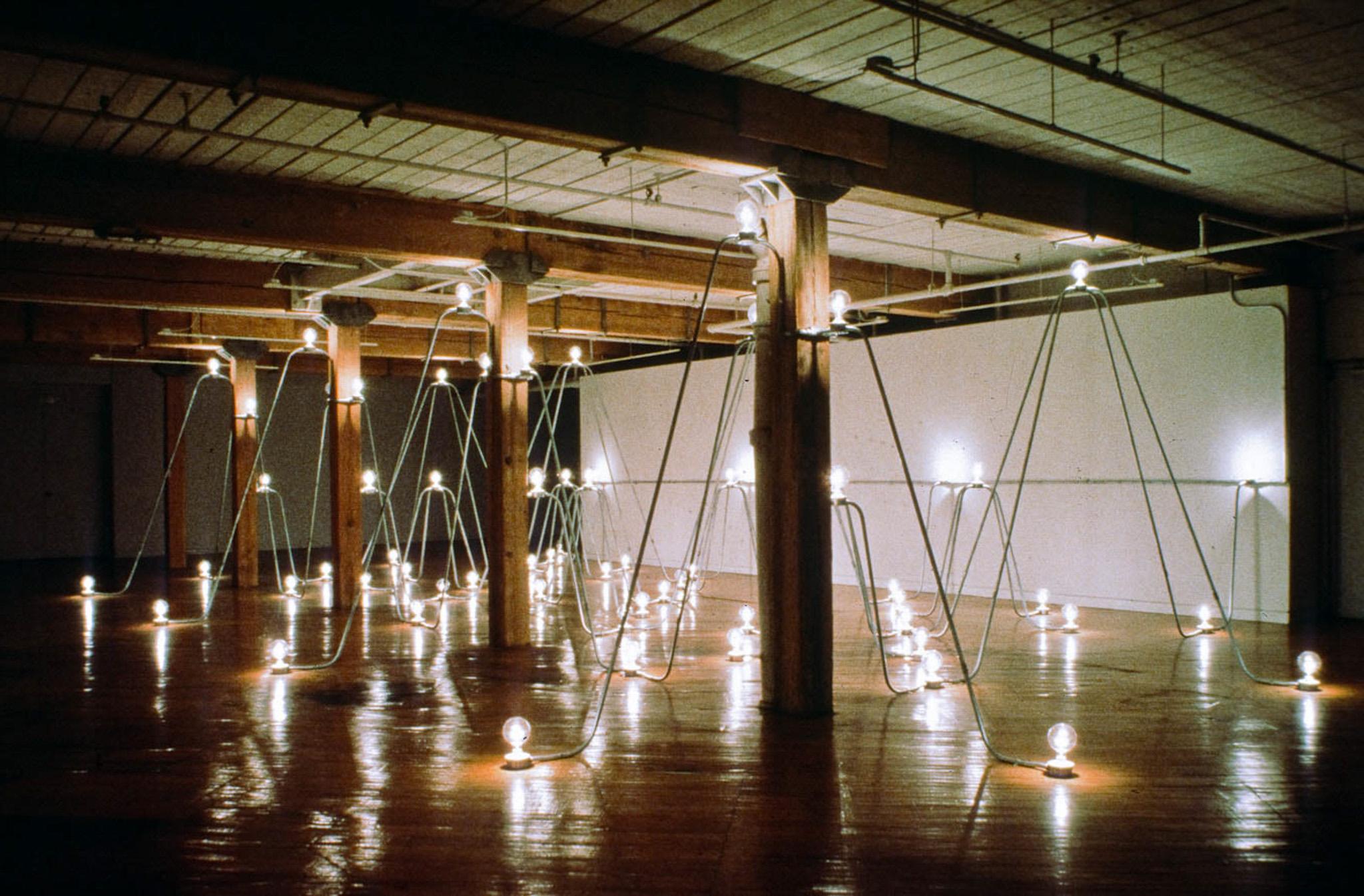 Nancy Holt's Electrical System made of conduit and lightbulbs installed in an exhibition space