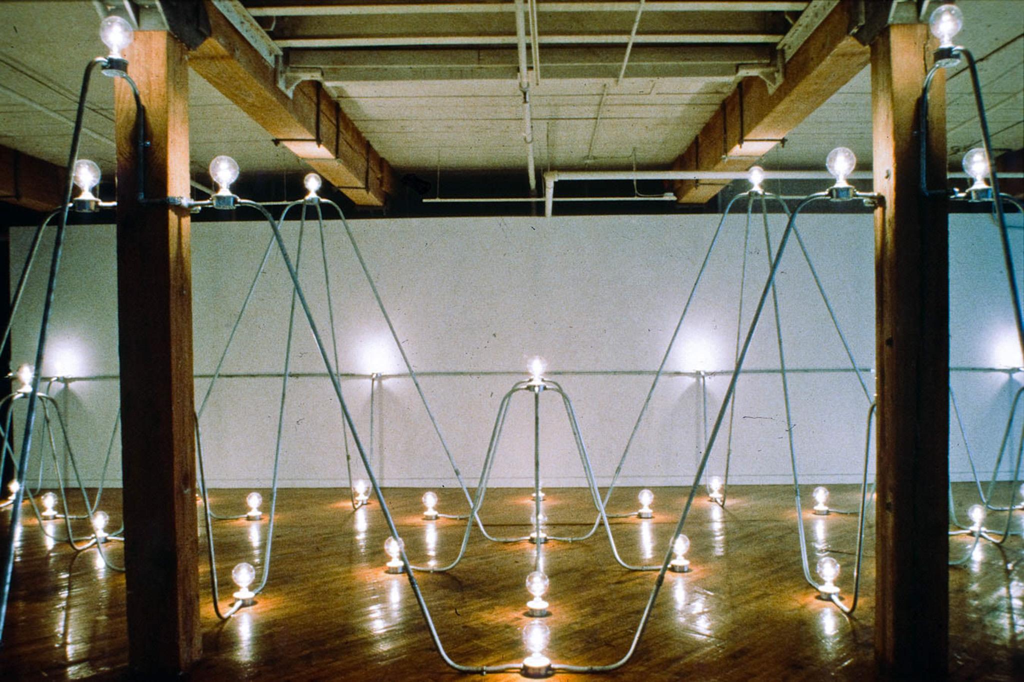 Nancy Holt's Electrical System made of conduit and lightbulbs installed in an exhibition space